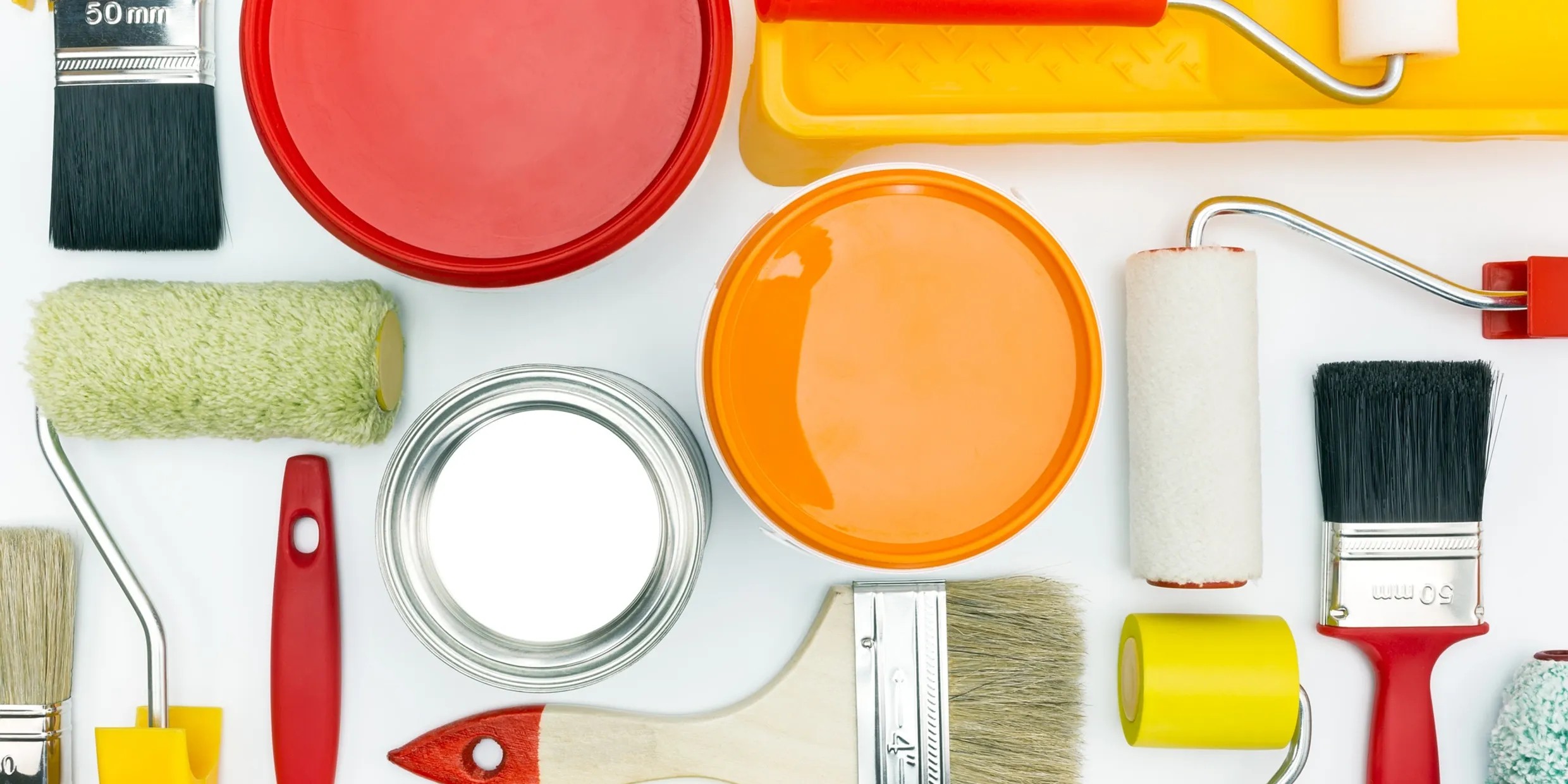 Painting tools and rollers arranged on a white surface